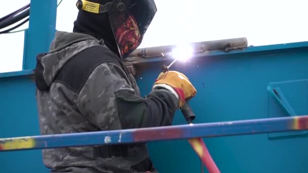 Lichtbogenschweißen eines Stahls auf der Baustelle. Clip. Mann mit Maske wird auf Baustelle geschweißt — Stockvideo