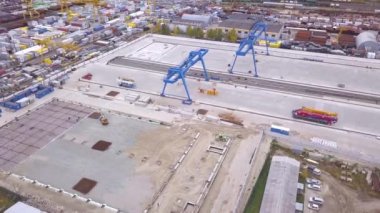 Santral Vinci en iyi görünümünü taşıma sitede. Küçük. Çeşitli marka ve renkler kaplar Transtainers mobil portal vinç hizmeti kamyon kapalı tarafından yığılmış nakliye