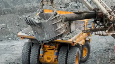 Ekskavatör damperli kamyon doldurur. Kova Ekskavatör closeup damperli kamyon araştırma ya da bir şey inşaatı gövdesini taşlar yükler