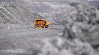 Kamyon sürüş kariyer yolu üzerinde. Damperli kamyon açık çukura mayınlı cevheri taşır. Arka plan açık beyaz çok aşamalı ocağı üzerinde araştırma sektöründe ağır büyük nakliye