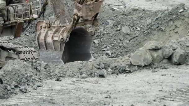 A escavadora está a cavar um buraco. Escavadeira cava poço no chão para construção ou mineração. Equipamento de mineração e pedreira — Vídeo de Stock