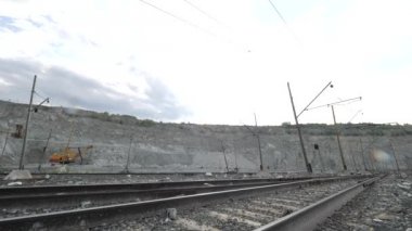 Arka plan açık çukurun demiryoluna. Madencilik sektörü ile ayakta Ekskavatör arka planda geçen demiryolu