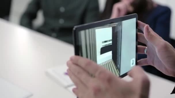 Виртуальный чертеж дома на планшете. На складе. Бизнесмен держит планшет с проектом виртуальной реальности дома в зале заседаний. Цифровая 3D модель проекта недвижимости показана на гаджете — стоковое видео