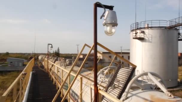 Bombas de aceite en el depósito de aceite. Acciones. Vieja granja de tanques en un día soleado. Concepto industria del combustible — Vídeo de stock