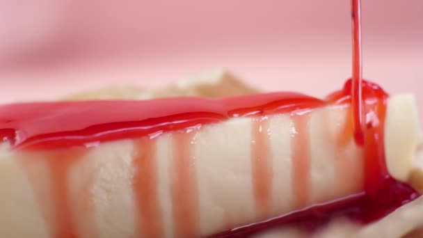 Close-up de cheesecake é derramado molho doce. Moldura. Delicioso cheesecake polvilhado doce engarrafamento vermelho. Conceito de sobremesas — Vídeo de Stock