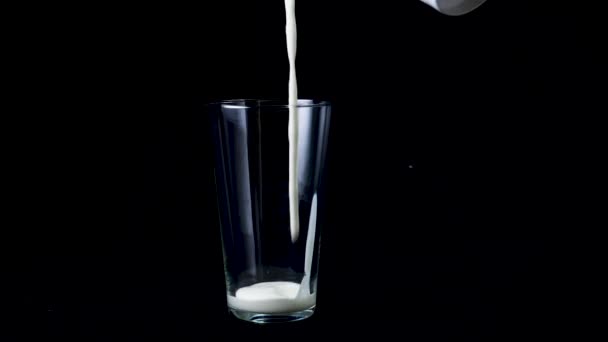 Nahaufnahme in Glas gießen weißen Joghurt. Rahmen. in transparentem, großem Glas weiße dicke Flüssigkeit auf schwarzem, isoliertem Hintergrund gießen — Stockvideo
