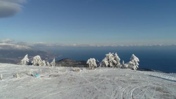 Luftaufnahme von verschneiten Bergen, Meer, bewölktem Himmel. Schuss. schneebedeckte Hügel am Meer — Stockvideo