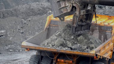 Ekskavatör damperli kamyon doldurur. Kova Ekskavatör closeup damperli kamyon araştırma ya da bir şey inşaatı gövdesini taşlar yükler