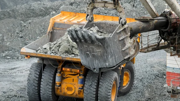 La cucharada de excavadora está cavando un agujero. Excavadora cava pozo en el suelo para la construcción o la minería. Equipos para minería y canteras — Foto de Stock