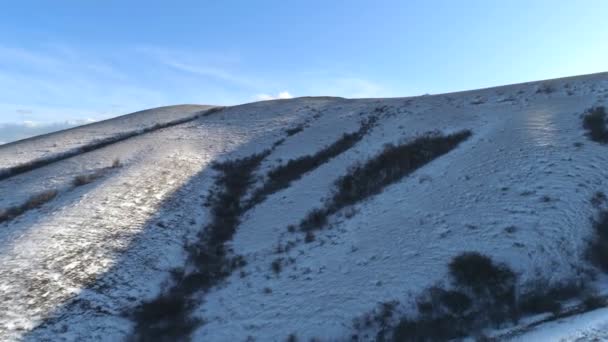 Зимовий пейзаж з пагорбами, вкритими снігом. Постріл. засніжені пагорби — стокове відео