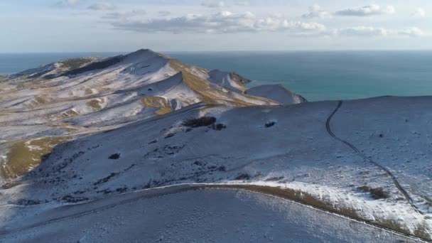 Зимовий пейзаж у бухті північного моря. Постріл. Пагорби покриті шаром снігу на блакитне небо . — стокове відео