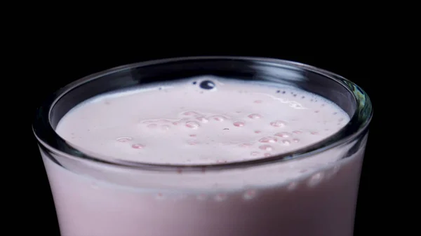 Close-up van glas met aardbei milkshake. Frame. Vers slagroom roze milkshake in helder glas op zwarte geïsoleerde achtergrond — Stockfoto