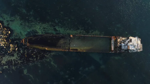 Vista aérea del barco arrastrado a tierra. Le dispararon. Vista superior de un viejo naufragio abandonado y oxidado en un día tormentoso —  Fotos de Stock