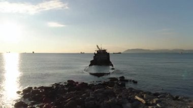 Paslı harap gemi mavi, bulutlu gökyüzü ve parlayan güneş arka plan mavi bir deniz battı. Vurdu. Suya yansıyan güneş ışığı ile deniz sahil yakınında düşen tekne.