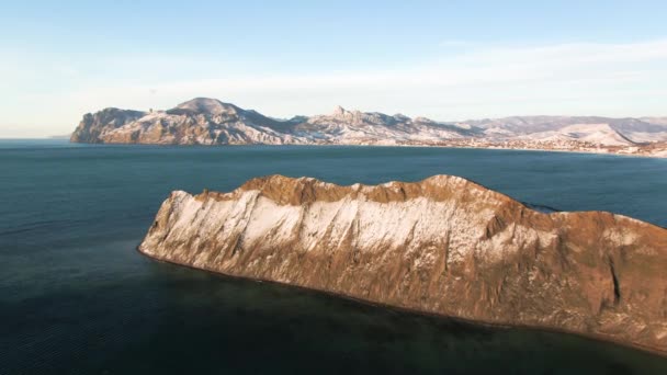 Aérea de dron volador de una pequeña isla en mar abierto. Le dispararon. Vista superior del acantilado de montaña junto al mar — Vídeo de stock