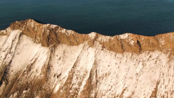 Aerial from flying drone of a little island in open sea. Shot. Top view of the mountain cliff by the sea — Stock Video