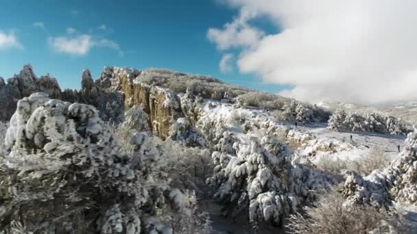 梦幻般的冬季景观的高山和雪林在多云, 蓝天背景。拍摄。阳光明媚的一天, 白色, 冬天的岩石和树木覆盖着雪对明亮的天空. — 图库视频影像