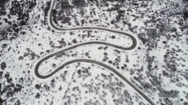 Hava kış manzara virajlı yol, karlı tepeleri ve bir sahil şeridi. Vurdu. Köy yolunda üstten görünüm karlı alanları ve deniz.