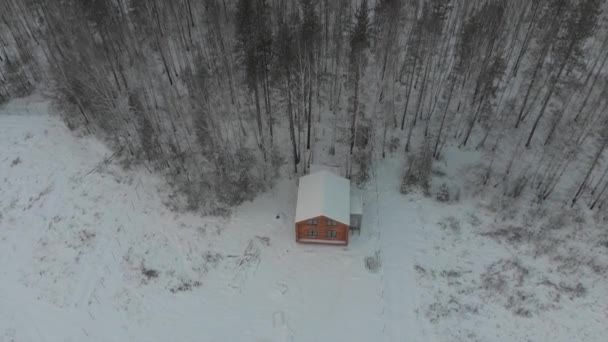 Widok z lotu ptaka na duży drewniany dom w pobliżu lasu zima. Magazynie. Życia na wsi — Wideo stockowe
