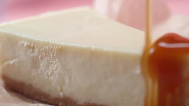 Délicieuse tranche de gâteau au fromage, qui est versé par un mince jet de sauce au caramel. Cadre. Gros plan — Video