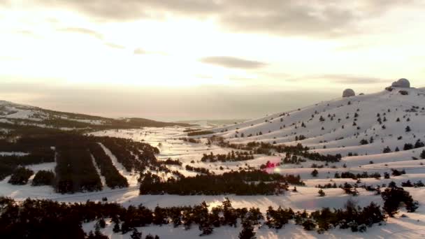 Αεροφωτογραφία του τον Αστροφυσικό Παρατηρητήριο χειμώνα στο χιονισμένο δάσος, Κριμαία. Βολή. Όμορφο τοπίο χιονισμένο πεύκα, παρατηρητήριο σε φόντο sunset, συννεφιασμένος ουρανός. — Αρχείο Βίντεο