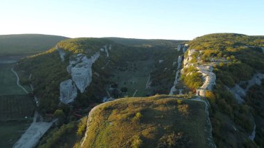 Güzel manzaralı dağ manzara sonbahar tepeler, mavi gökyüzü bulutlu ve sisli ufuktan yükselen güneş ışığı ile. Vurdu. Güzel dağ manzarası. Üstündeki eski bir taş kapısı yoktur.