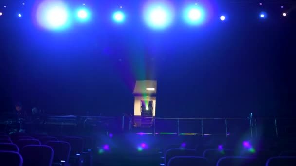 Dunkler, leerer Kinosaal mit bequemen Sitzen in blauem Licht, Projektor und hellen Scheinwerfern. Nahaufnahme für Sitzreihen im Kino. — Stockvideo