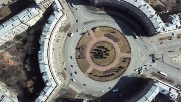 Top view of roundabout in city center. Roundabout with busy traffic of cars, surrounded by houses in city center on sunny day — Stock Video