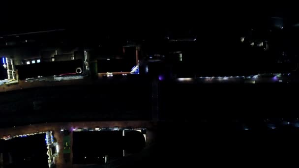 夜からの光の反射の平面図を収容します。家の明かりを照らす夜市と川と小さな運河の通り — ストック動画