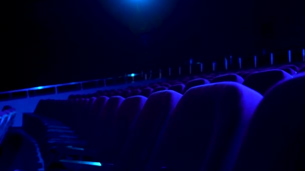 Sala de cine oscura y vacía con cómodos asientos en luz azul. Primer plano para las filas de asientos en el cine . — Vídeo de stock