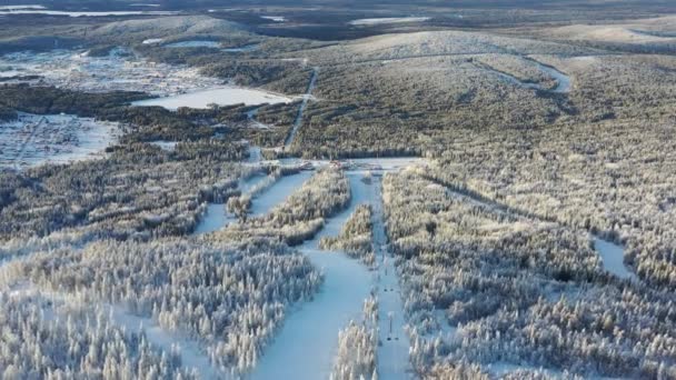 Flygfoto över linbanan stugor och skidorten omgiven av skog i vinter. Footage. Utomhussporter — Stockvideo