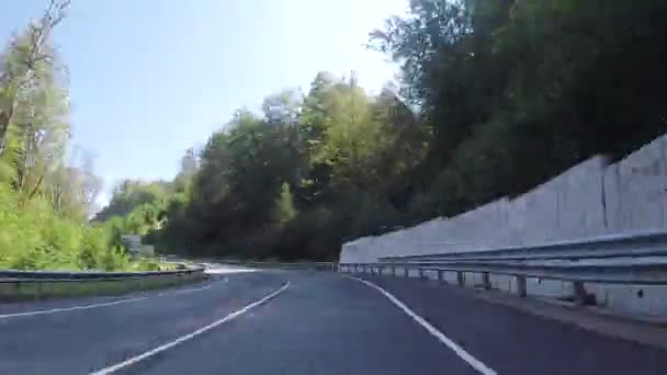 Déplacement vers l'avant de la voiture sur l'autoroute serpentine, entouré de collines boisées, vue du conducteur. Scène. Perspective à la première personne de la route depuis le véhicule . — Video