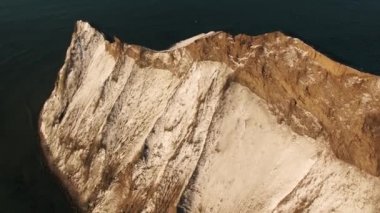 Koyu mavi su denize sıfır kar kaplı kahverengi dağ yamacı hava görünümünü. Vurdu. Güzel manzara