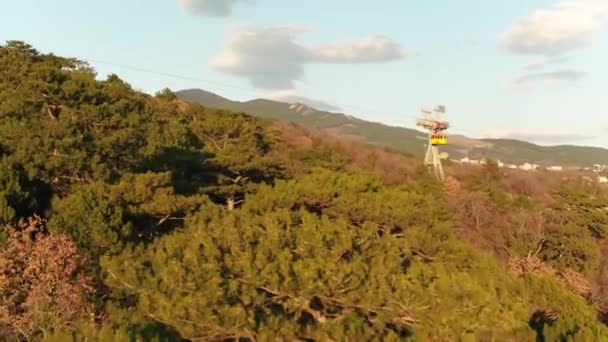 Luftaufnahme der Seilbahnen über dem herbstlichen Wald vor blauem wolkenverhangenem Himmel. Schuss. Berglandschaft. — Stockvideo