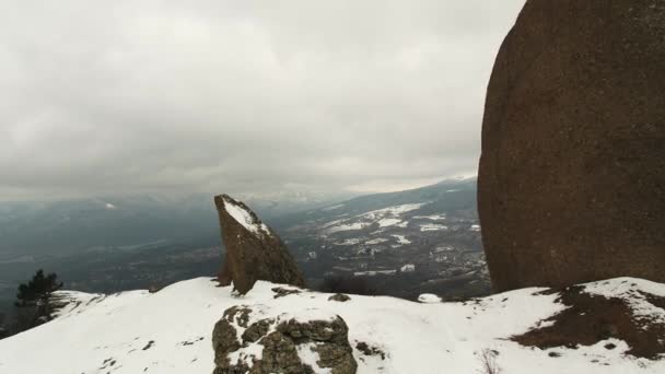 Vista aerea dall'alto su vecchie montagne e foresta ricoperta di neve contro nuvole grigie. Gli hanno sparato. Paesaggio serale . — Video Stock