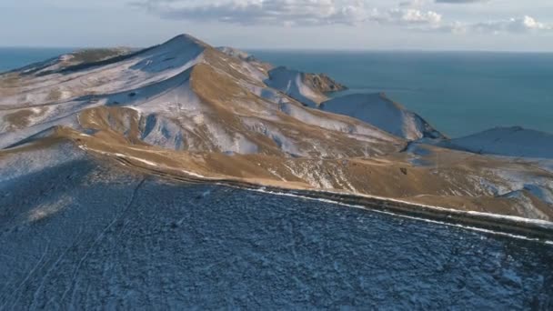 Vista aérea da cordilheira no inverno perto do mar contra o céu azul nublado. Atingido. Bela paisagem . — Vídeo de Stock