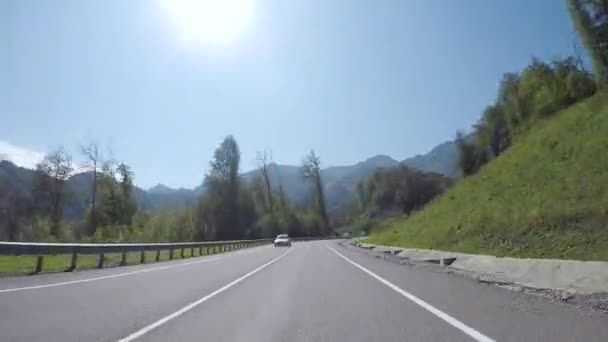 Spostamento in avanti della vettura sulla strada serpentina, circondato da colline boscose, vista conducente. Scena. Prospettiva in prima persona della strada dalla guida del veicolo . — Video Stock