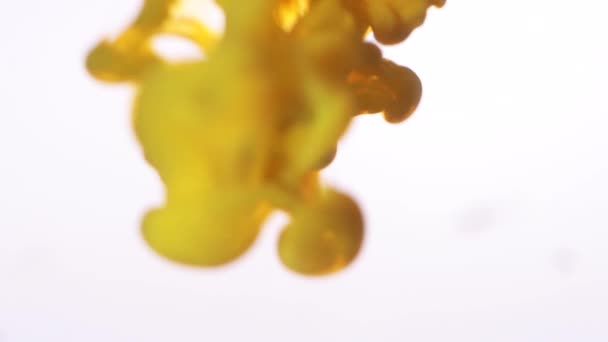 Close-up of yellow coloring ink mixing in water texture on a white background. Abstract background. — Stock Video