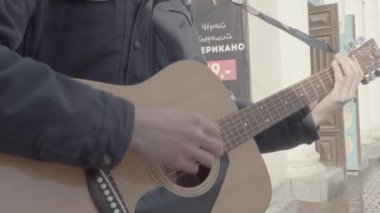 Beyaz görünümünü yakın çekim sokakta gitar çalmak eller mans. Müzik sokak kültürü.