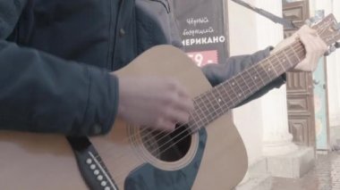 Beyaz görünümünü yakın çekim sokakta gitar çalmak eller mans. Müzik sokak kültürü.