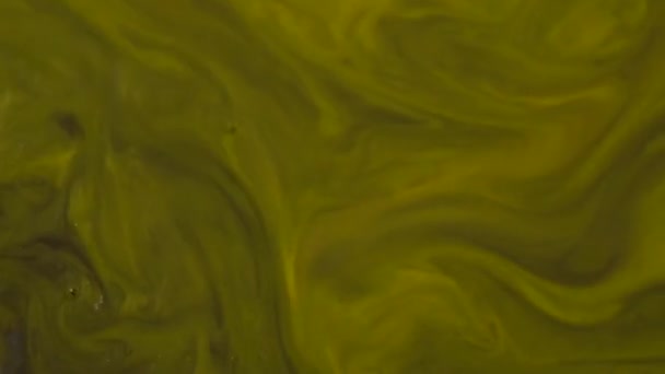 Gros plan de peinture acrylique jaune mélangée à de l'eau. Texture acrylique dorée .