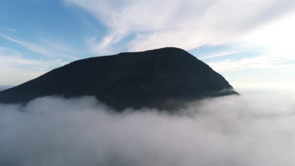 Luchtfoto van bergtop in wolken tegen blauwe hemel. Berglandschap. — Stockvideo