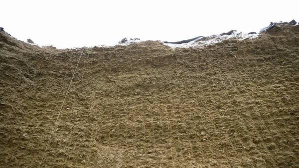 Огромный стог сена. Запись. Сырая огромная стена из сжатого сена для запасов зимой для кормления скота. Сельское хозяйство и хранение сена — стоковое фото