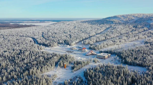 Vista superior de la estación de esquí a pie de montaña. Filmación. La estación de esquí aislada a pie de colina con pistas de esquí es popular en la temporada de invierno. Día claro y soleado en las pistas de esquí de la estación de invierno — Foto de Stock