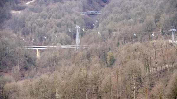 Vista superior do teleférico sobre a ponte. O teleférico passa pela floresta selvagem fora da cidade no outono. Área de floresta de montanha com pontes e teleférico — Fotografia de Stock