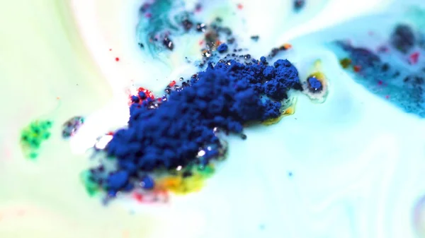 Colorful powder paint on milk. Close-up of powder paint floating moves on surface of white liquid. Crushed colorful pastel paint for art — Stock Photo, Image