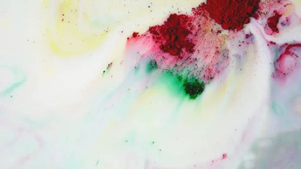 Colorful powder paint on of milk. Close-up of colorful red and green powder paint placer on white liquid surface