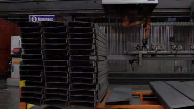 Depo birçok metal plakalar ve çalışan, endüstri kavramı insanlar. Sahne. Metal yapılar ambar saclar ve bir fabrikada işçiler ile.