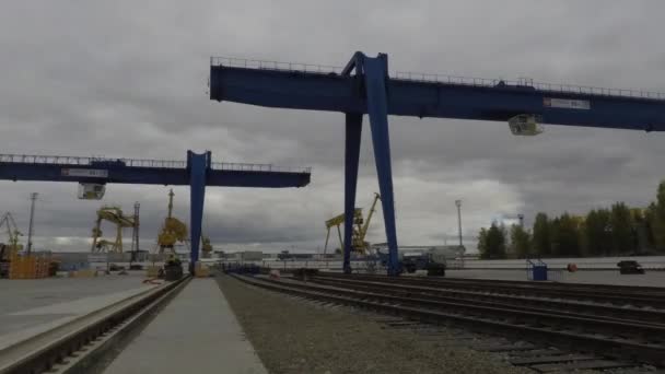 Duże Dźwigi kozłowe logistyka transport Company na tło szare, pochmurne niebo. Suwnic, dźwigów samochodowych i osób wykonujących prace załadunku, upływ czasu. — Wideo stockowe