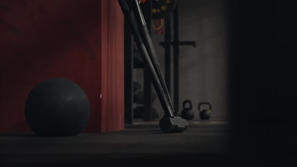 Close-up van sportartikelen in de sportschool. Zwarte fitness bal en rod nek op achtergrond van kettlebells en donkere muren van sporthal — Stockvideo